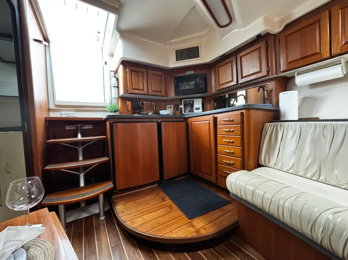 Martuni Yacht Photos Pics 2002 Luhrs 40 Open yacht interior with wooden cabinetry, kitchenette, and seating area.