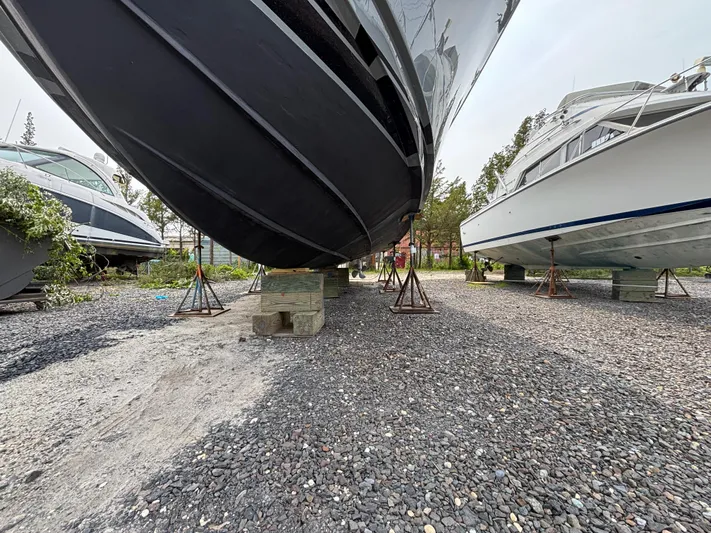 Martuni Yacht Photos Pics 2002 Luhrs 40 Open boat on stands, gravel lot, side view.