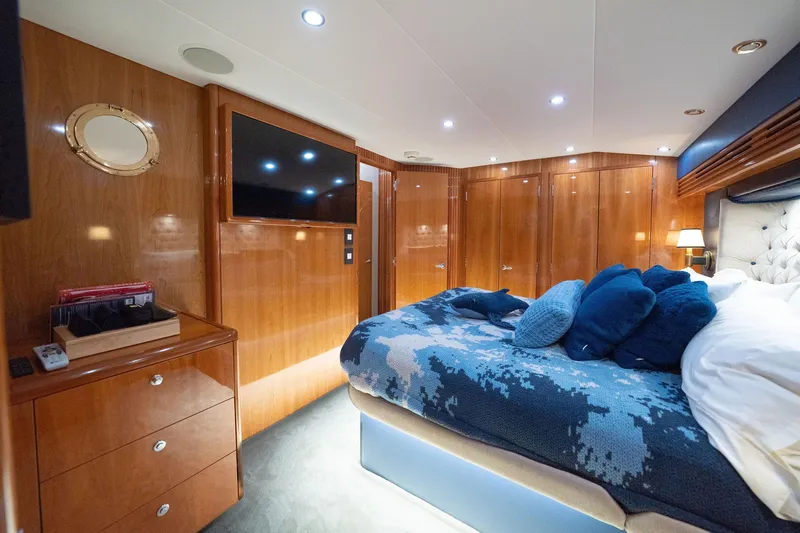 Ventura Yacht Photos Pics Luxurious cabin interior of 2005 Hatteras 60 Convertible yacht with wood paneling and plush bedding.