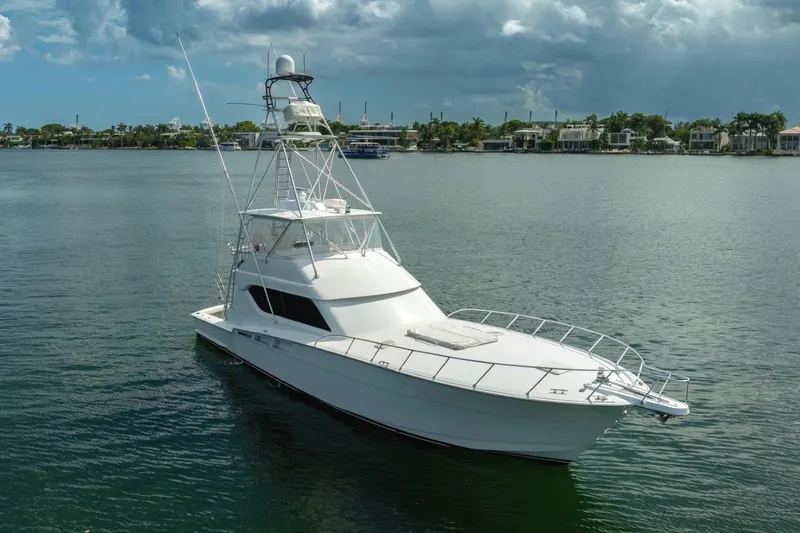 Ventura Yacht Photos Pics 2005 Hatteras 60 Convertible yacht on calm water under cloudy sky.