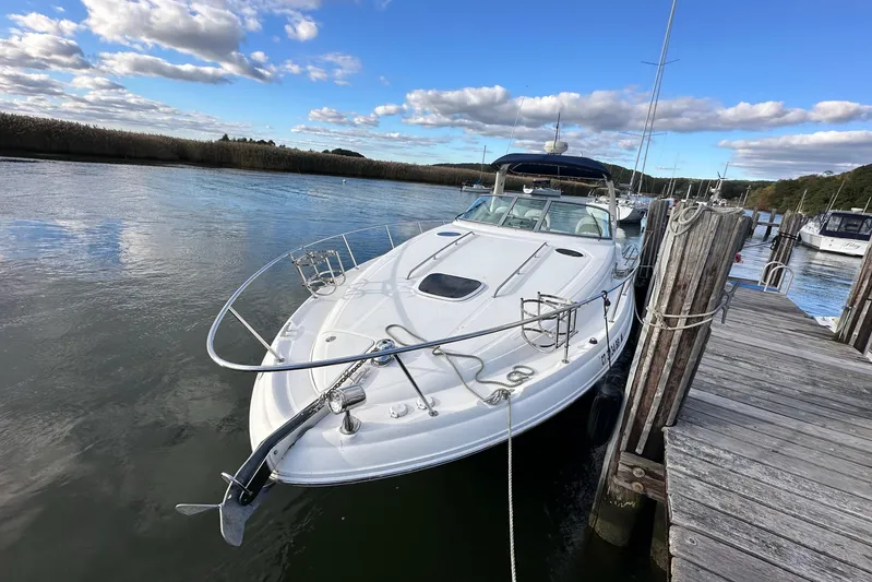  Yacht Photos Pics 2006 Sea Ray 340 Sundancer docked on a calm river under a blue sky.