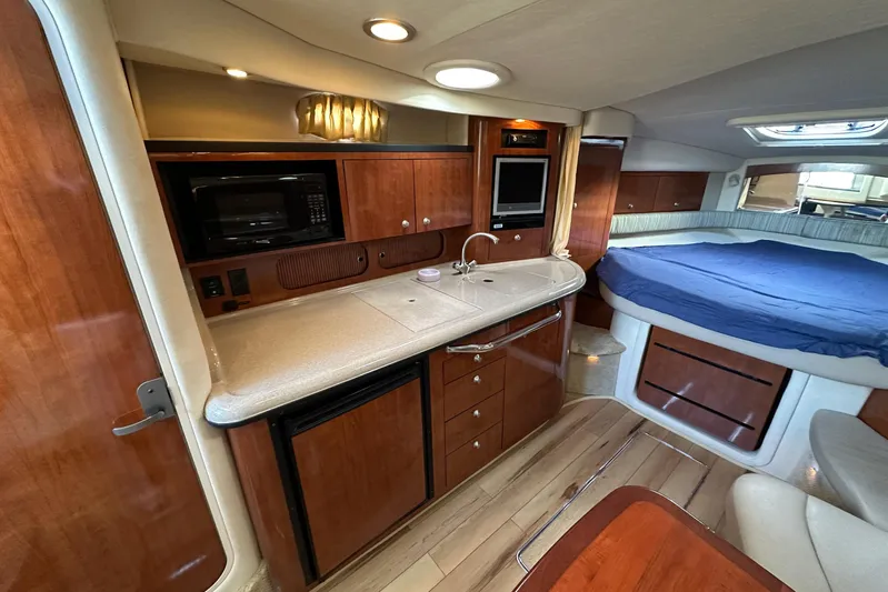  Yacht Photos Pics 2006 Sea Ray 340 Sundancer interior with kitchenette, bed, and wood cabinetry.