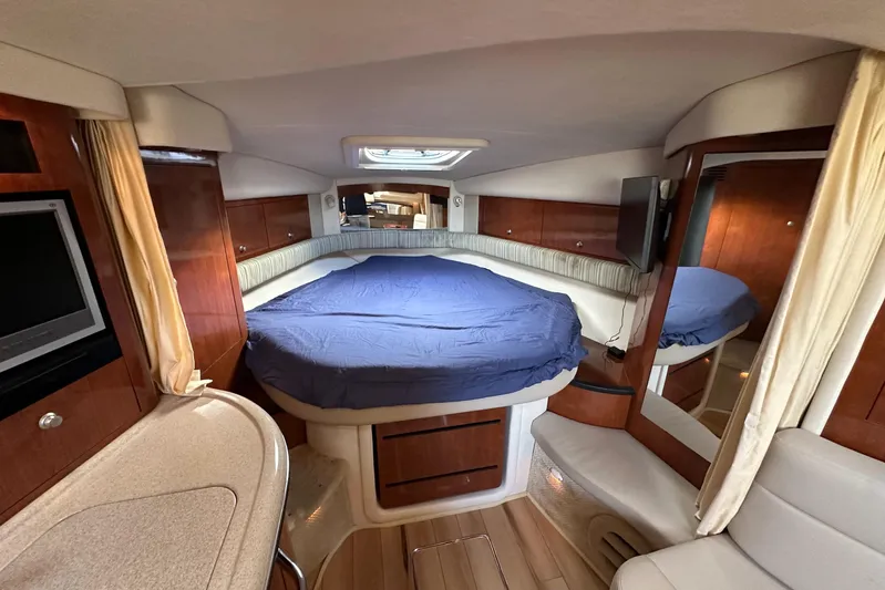  Yacht Photos Pics 2006 Sea Ray 340 Sundancer cabin interior with bed, TV, and wood accents.