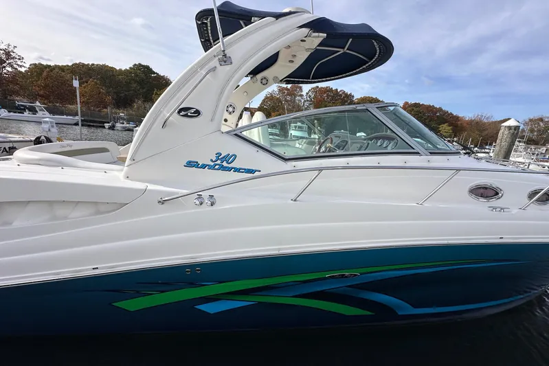  Yacht Photos Pics 2006 Sea Ray 340 Sundancer boat docked, featuring sleek design and vibrant blue-green accents.