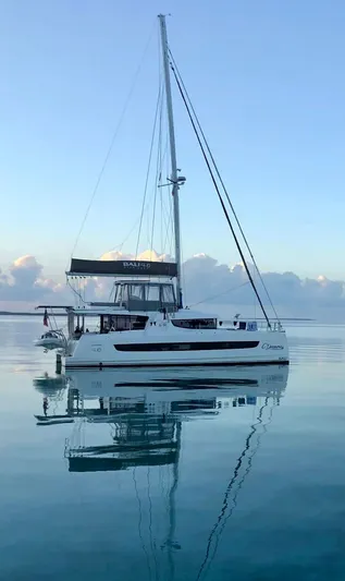 C Dreams Yacht Photos Pics Sailing catamaran Bali 4.6, 2022 model, reflected on calm water at sunrise.