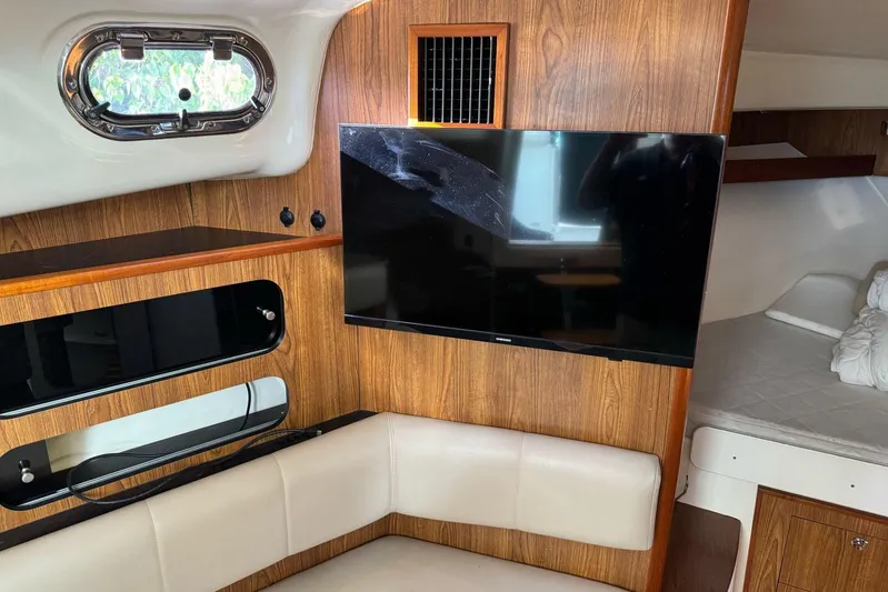  Yacht Photos Pics Interior of 2009 Pursuit OS 375 Offshore boat with TV and seating area.