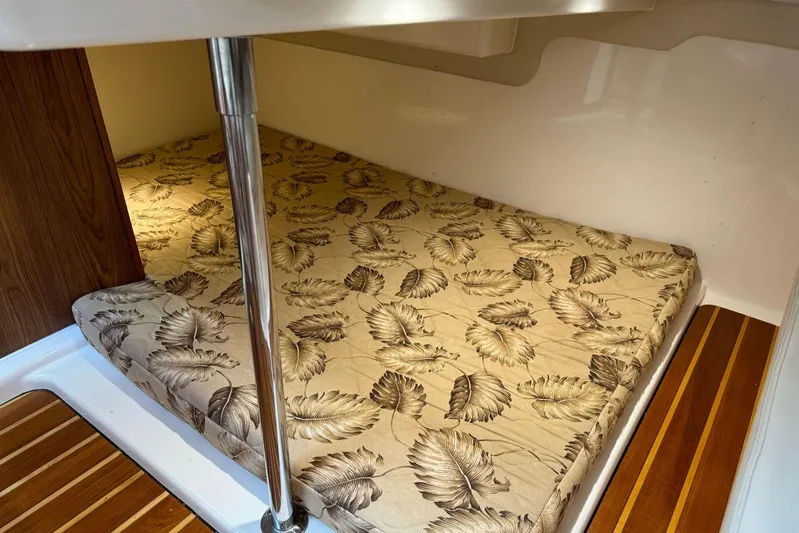  Yacht Photos Pics 2009 Pursuit OS 375 Offshore cabin with leaf-patterned bedding and wooden flooring.