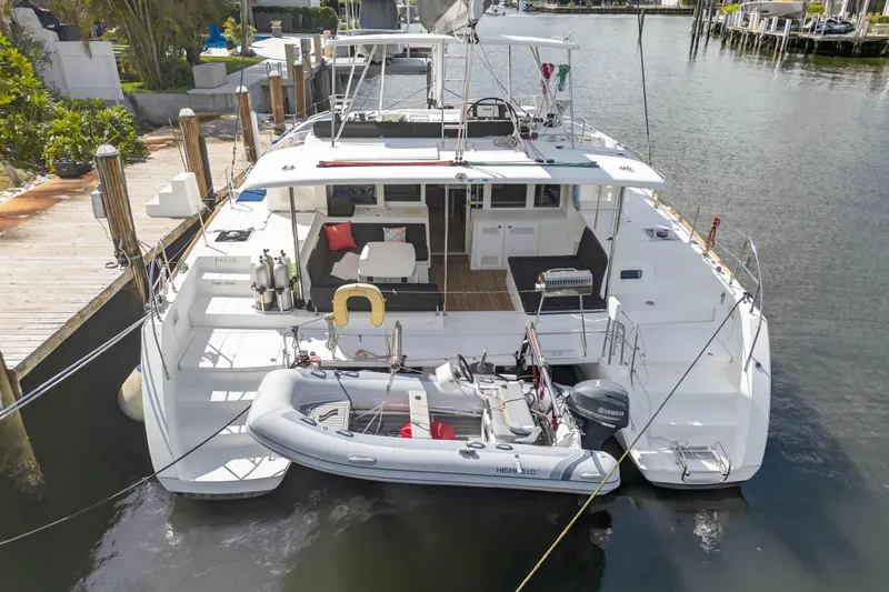  Yacht Photos Pics 2019 Lagoon 450 F catamaran docked with inflatable boat, spacious deck, and seating area.