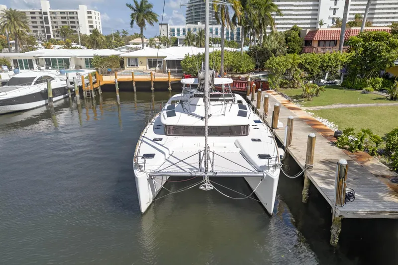  Yacht Photos Pics 2019 Lagoon 450 F catamaran docked in a scenic marina with palm trees.