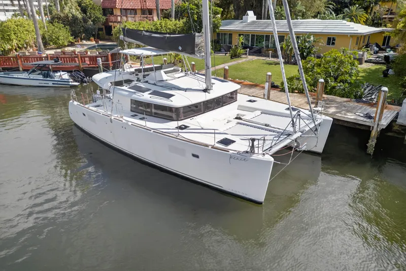  Yacht Photos Pics 2019 Lagoon 450 F catamaran docked by a waterfront property.