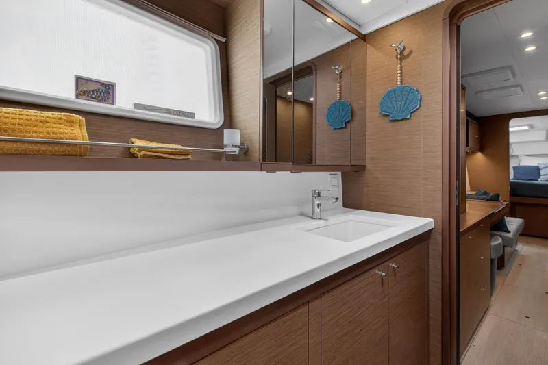  Yacht Photos Pics Luxurious 2019 Lagoon 450 F yacht interior with modern bathroom and wooden cabinetry.