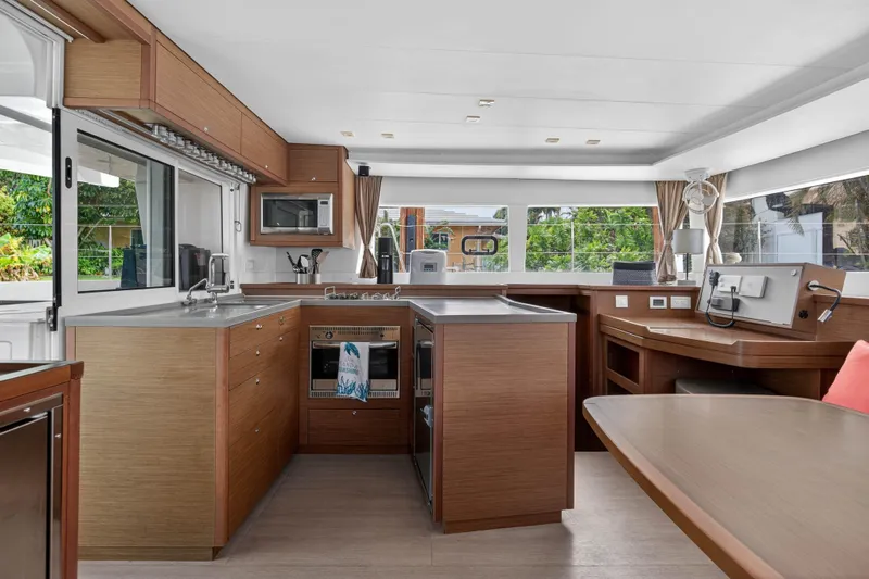  Yacht Photos Pics Modern kitchen interior of 2019 Lagoon 450 F catamaran with wood cabinetry and appliances.