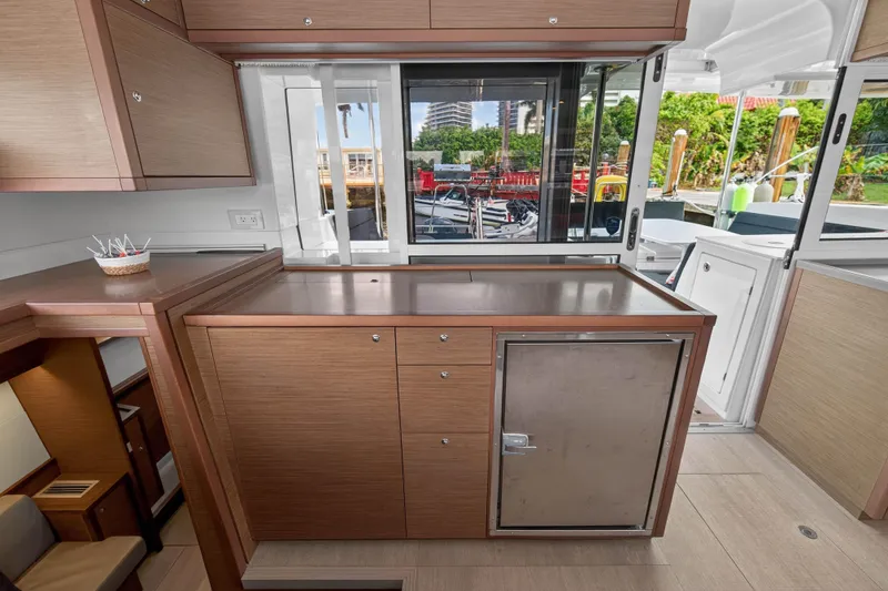  Yacht Photos Pics Interior of 2019 Lagoon 450 F yacht with modern wooden cabinetry and outdoor view.