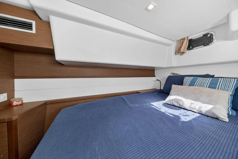  Yacht Photos Pics Cozy cabin interior of 2019 Lagoon 450 F yacht with blue bedding and wooden accents.