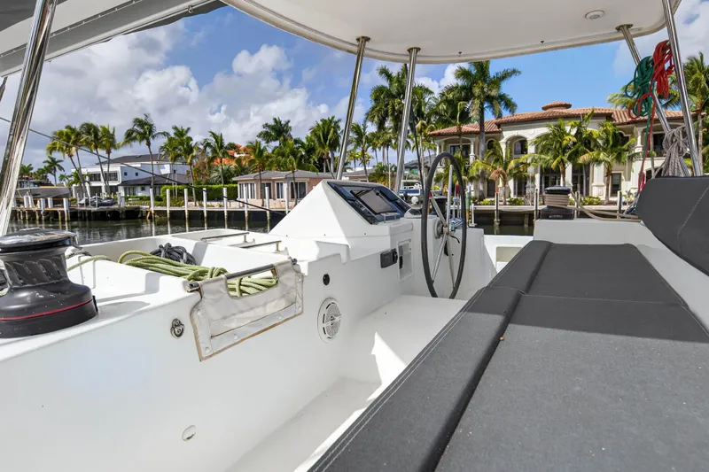  Yacht Photos Pics 2019 Lagoon 450 F yacht cockpit with luxurious waterfront view and palm trees.