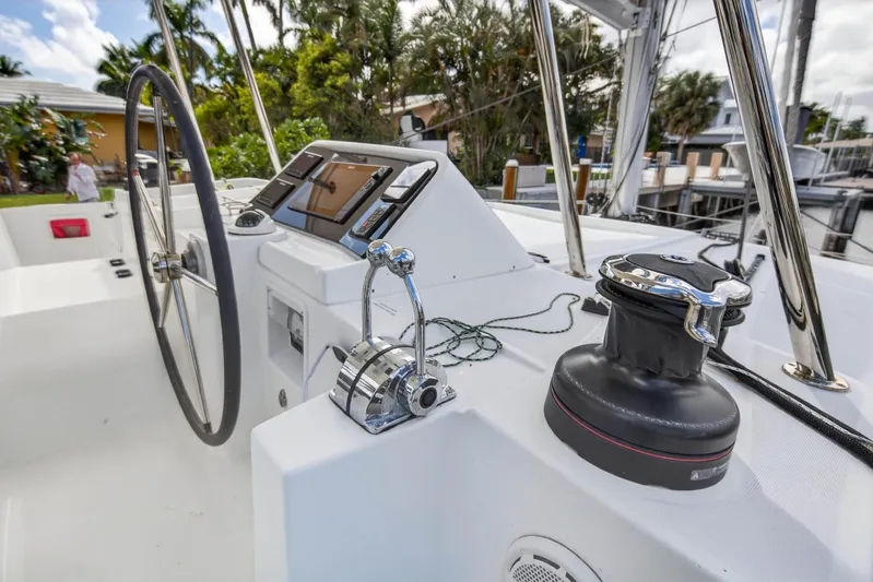  Yacht Photos Pics Steering wheel and controls of 2019 Lagoon 450 F catamaran, docked with lush surroundings.