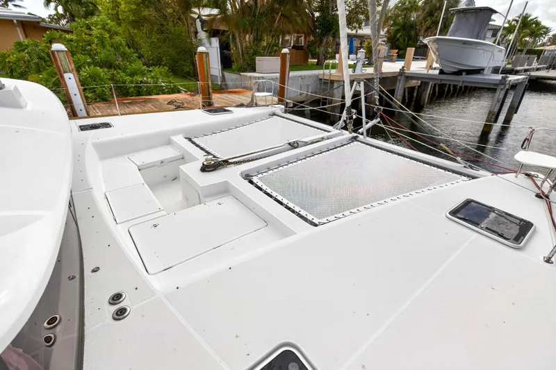  Yacht Photos Pics 2019 Lagoon 450 F catamaran deck with storage compartments and dock view.