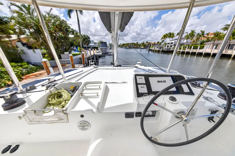  Yacht Photos Pics 2019 Lagoon 450 F yacht helm with navigation equipment, docked in a scenic canal.