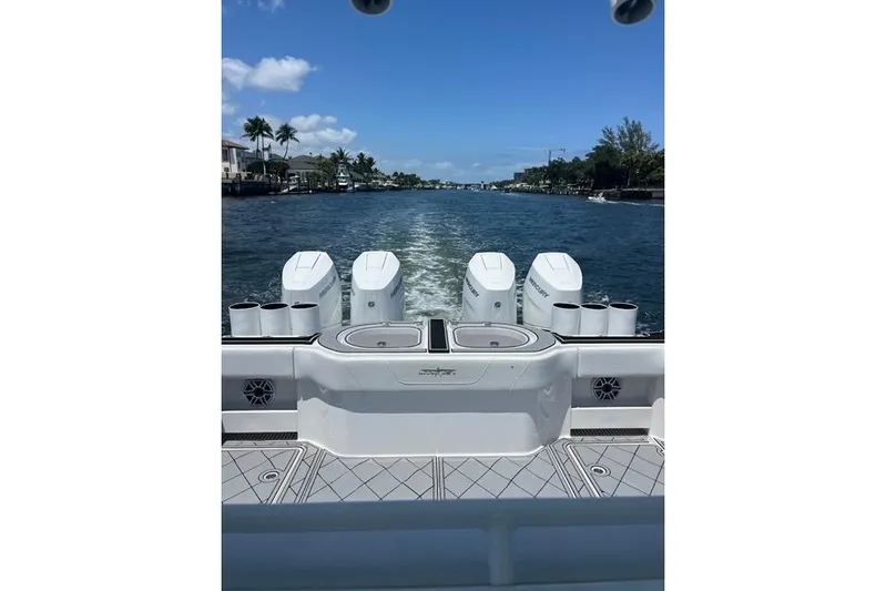  Yacht Photos Pics 2020 Invincible 40 Catamaran cruising on a sunny waterway with palm trees.