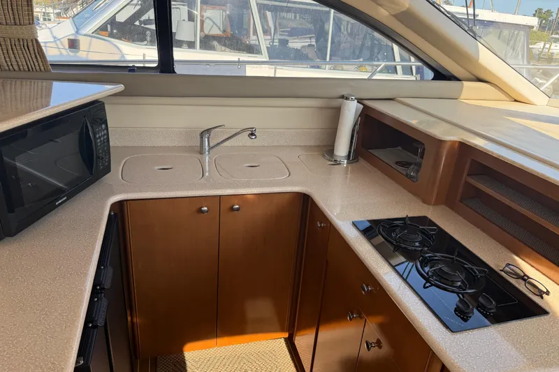 Her Idea Yacht Photos Pics 2005 Meridian 381 yacht kitchen with microwave, stove, and sink.