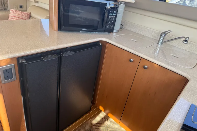 Her Idea Yacht Photos Pics Kitchen area of 2005 Meridian 381 yacht with microwave, sink, and cabinets.