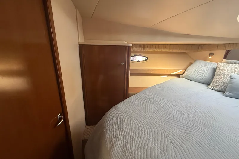 Her Idea Yacht Photos Pics Cozy bedroom interior of 2005 Meridian 381 yacht with elegant bedding and wooden cabinetry.