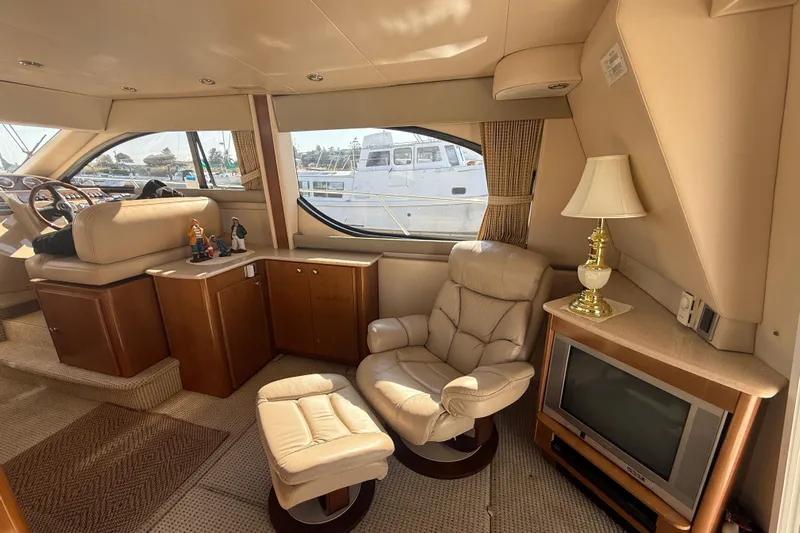 Her Idea Yacht Photos Pics Luxurious interior of 2005 Meridian 381 yacht with leather chair, TV, and lamp.