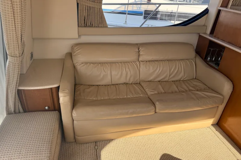 Her Idea Yacht Photos Pics Beige leather sofa in 2005 Meridian 381 yacht interior, with window and wooden cabinetry.