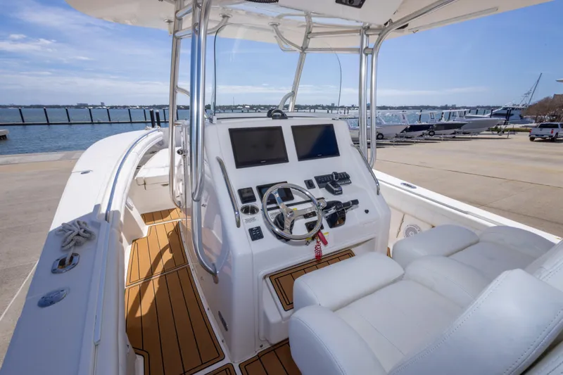 Change Order Yacht Photos Pics 2018 Regulator 31 boat cockpit with dual screens and white seating, docked by the water.