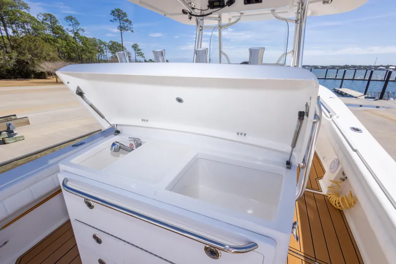 Change Order Yacht Photos Pics 2018 Regulator 31 boat with open storage compartment and sink, dockside view.
