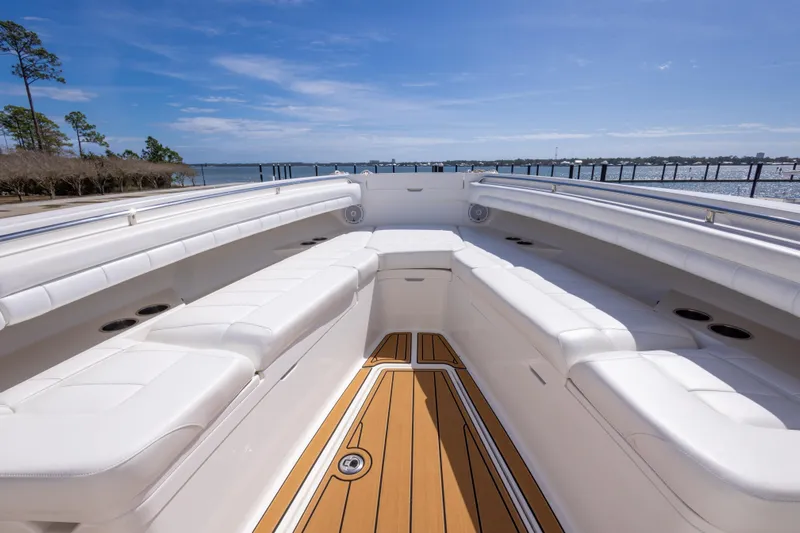 Change Order Yacht Photos Pics 2018 Regulator 31 boat with spacious white seating and wooden deck, docked by the water.