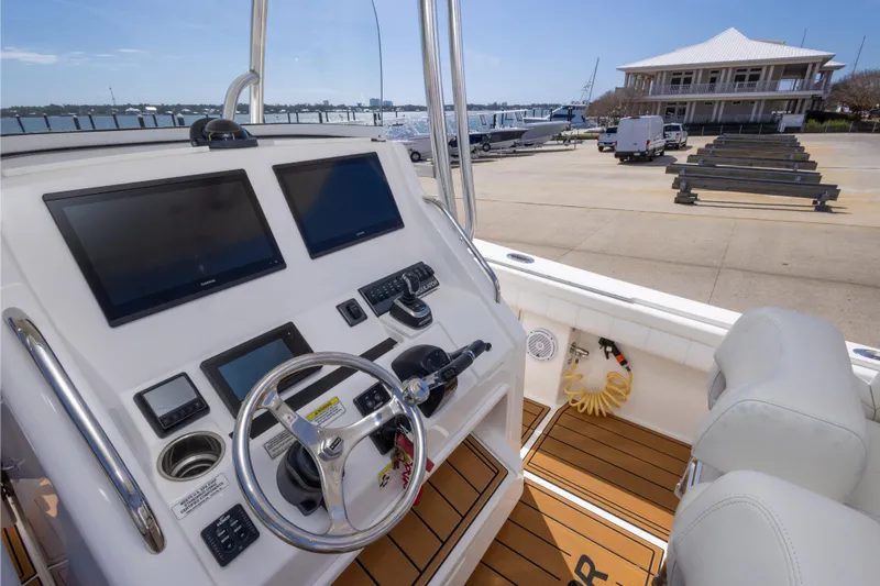 Change Order Yacht Photos Pics 2018 Regulator 31 boat cockpit with dual screens and steering wheel at marina.