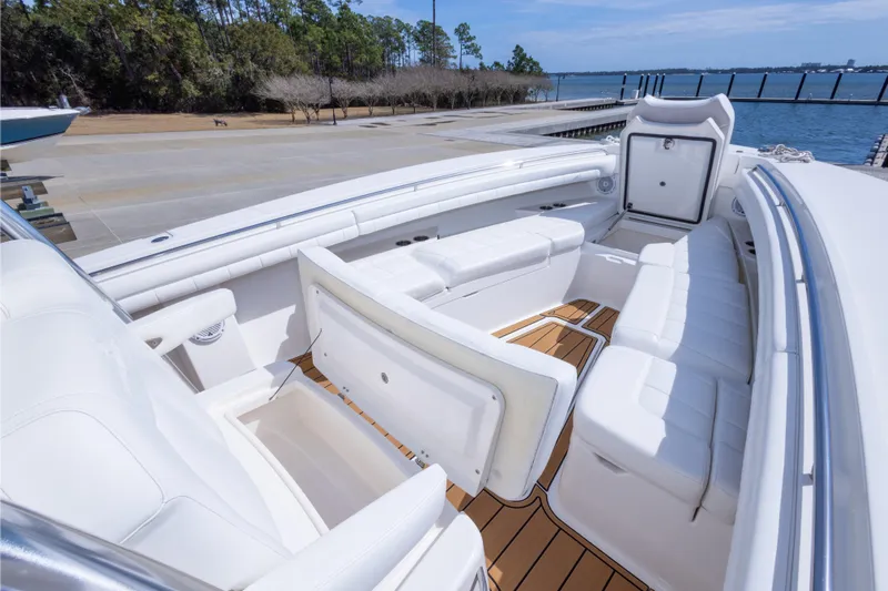 Change Order Yacht Photos Pics 2018 Regulator 31 boat interior with white seating and teak flooring by the water.