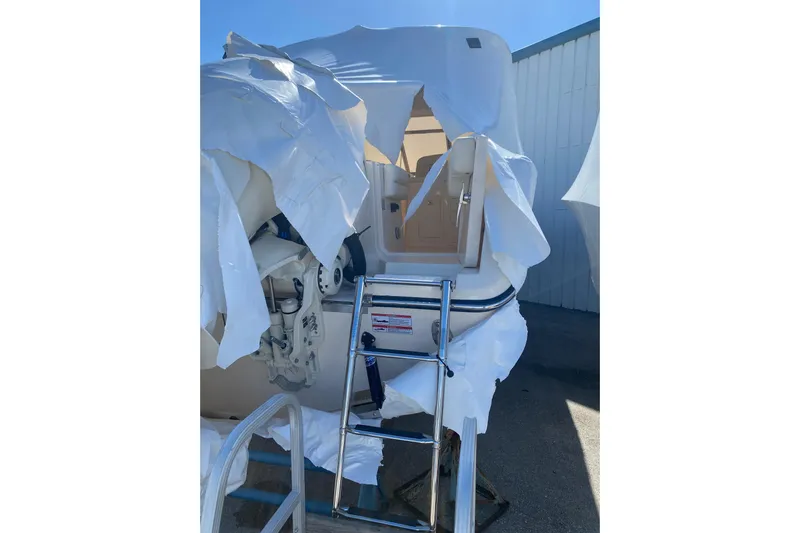  Yacht Photos Pics 2026 Grady-White Freedom 307 boat partially covered, with ladder and engine visible.