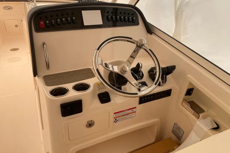  Yacht Photos Pics 2026 Grady-White Freedom 307 boat helm with steering wheel and control panel.