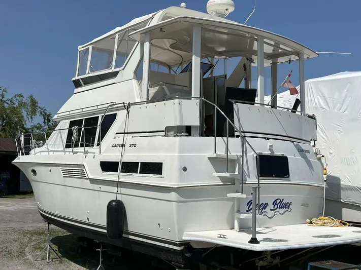 Yacht Photos Pics 1996 Carver 370 Aft Cabin yacht on land, white exterior, rear view.
