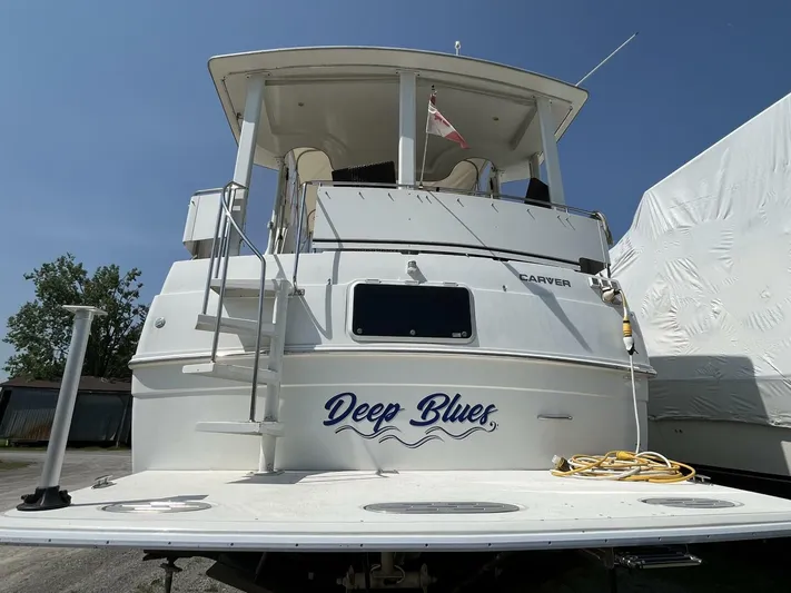  Yacht Photos Pics 1996 Carver 370 Aft Cabin boat named "Deep Blues" docked with visible ladder and flag.