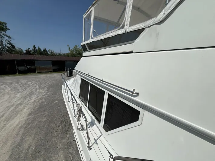  Yacht Photos Pics 1996 Carver 370 Aft Cabin yacht on land, side view with clear sky.