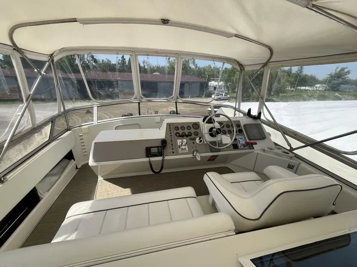  Yacht Photos Pics 1996 Carver 370 Aft Cabin helm with white seating, steering wheel, and control panel.