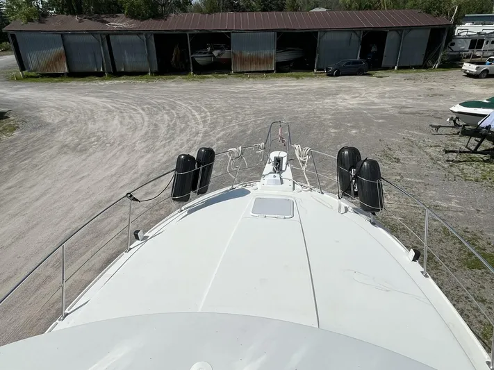  Yacht Photos Pics 1996 Carver 370 Aft Cabin boat docked, view from bow, storage sheds in background.