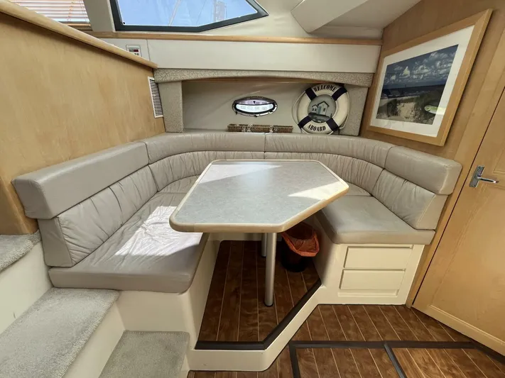  Yacht Photos Pics 1996 Carver 370 Aft Cabin interior with beige seating, dining table, and nautical decor.