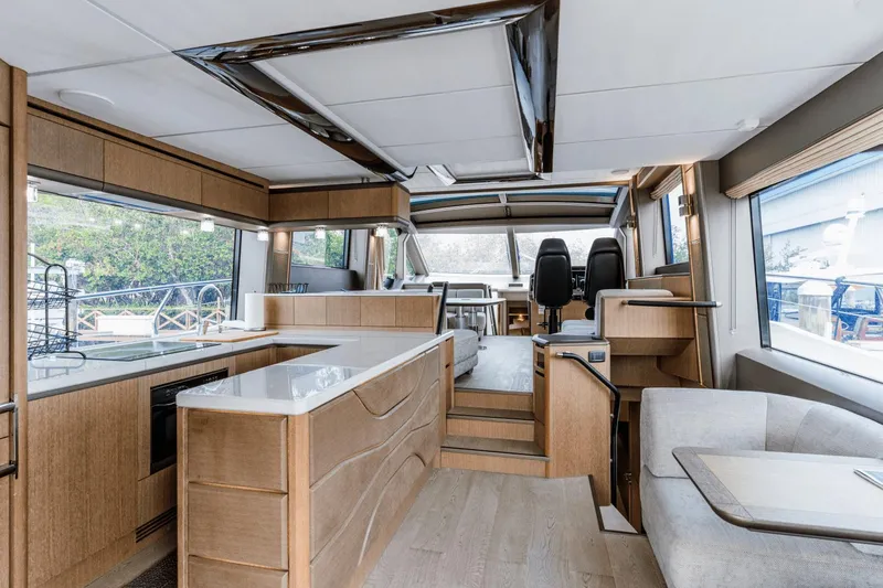 Live More Yacht Photos Pics Luxurious interior of 2021 Galeon 680 Fly yacht with modern kitchen and seating area.