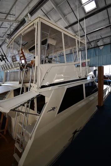 Stormy Yacht Photos Pics 1988 Viking 48 Convertible yacht in a marina, showcasing its sleek design and upper deck.