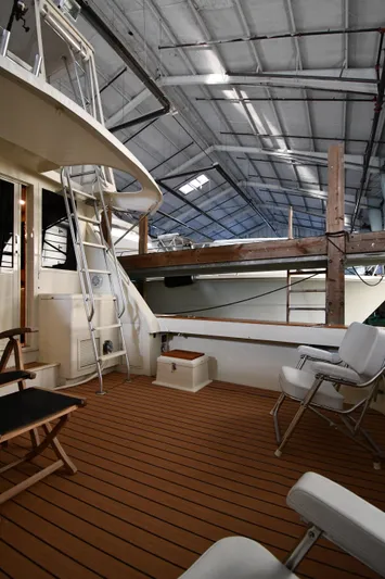 Stormy Yacht Photos Pics 1988 Viking 48 Convertible yacht deck with seating and ladder in a covered marina.