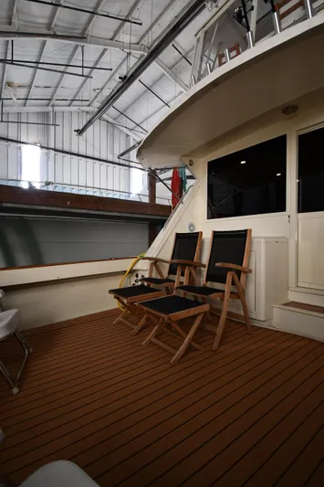 Stormy Yacht Photos Pics 1988 Viking 48 Convertible yacht deck with wooden chairs in a boat shed.