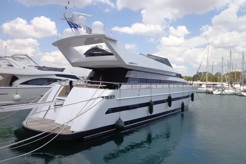 Galini Yacht Photos Pics Luxury yacht Cantieri di Pisa 27s, 2001 model, docked in a marina under a cloudy sky.