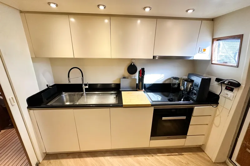 Galini Yacht Photos Pics Modern kitchen interior on 2001 Cantieri di Pisa 27s yacht, featuring sleek cabinetry and appliances.