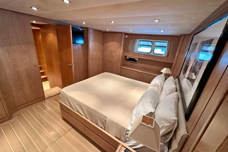 Galini Yacht Photos Pics Luxurious 2001 Cantieri di Pisa 27s yacht bedroom with elegant wood paneling and cozy lighting.