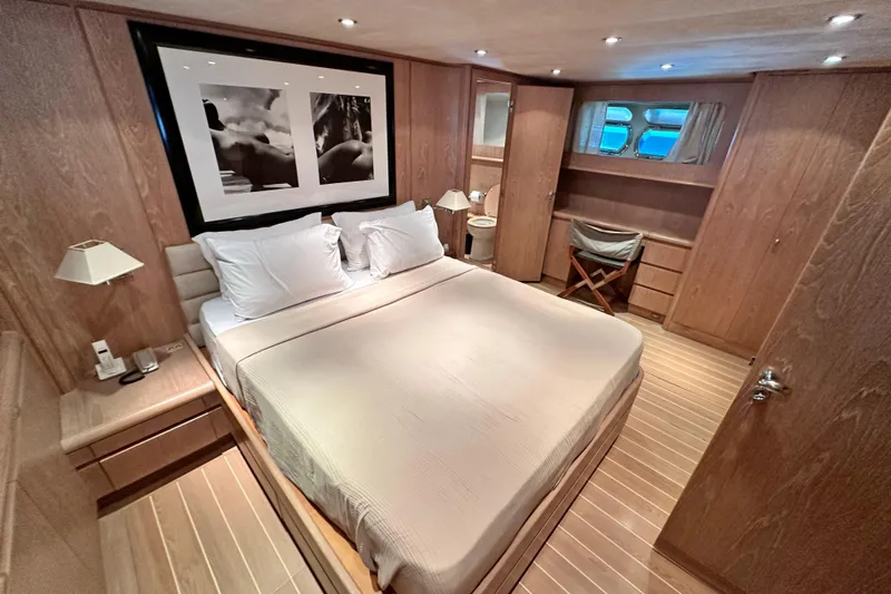 Galini Yacht Photos Pics Luxurious bedroom interior on 2001 Cantieri di Pisa 27s yacht, featuring elegant wood finishes.