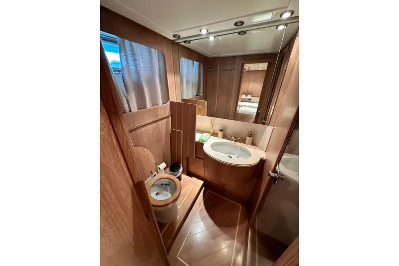 Galini Yacht Photos Pics Luxurious bathroom in 2001 Cantieri di Pisa 27s yacht, featuring wood accents and modern fixtures.